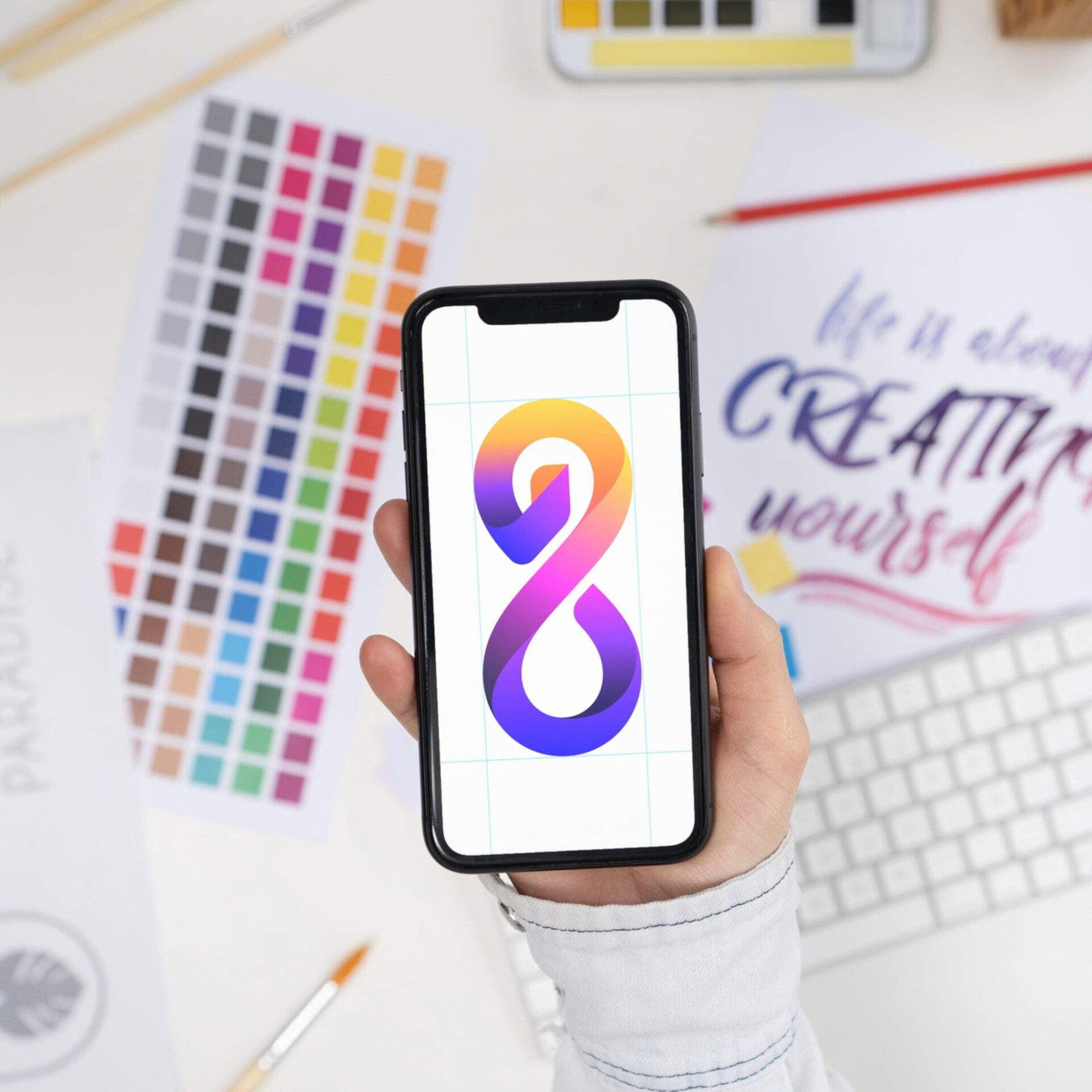 Logo designer holding a smartphone with a cool logo on it architects-looking-documents-desk